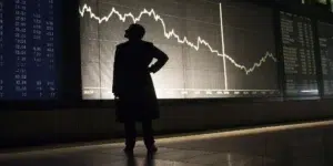 Investor analyzing stock market data on a computer screen.